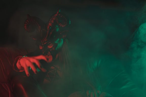 Mysteriöser charismatischer Charakter in einer nebligen, farbigen Umgebung.