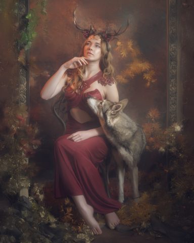 Frau in rotem Kleid mit Hirschgeweihen, sitzt mit einem Wolf in herbstlicher Umgebung.